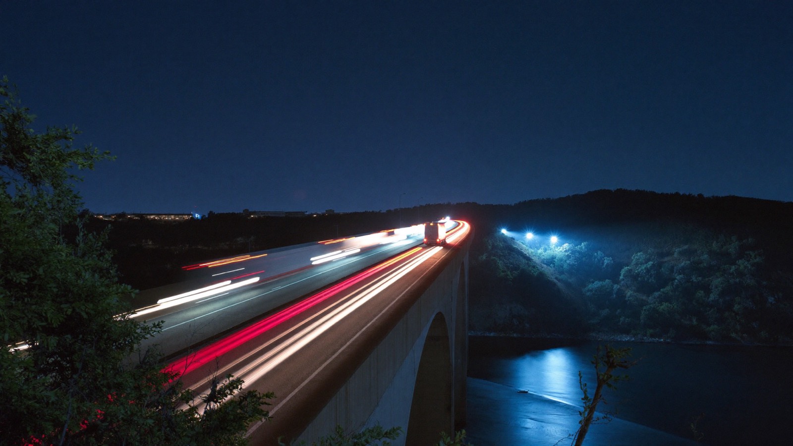 Autopista española de noche con estelas de luces de camiones